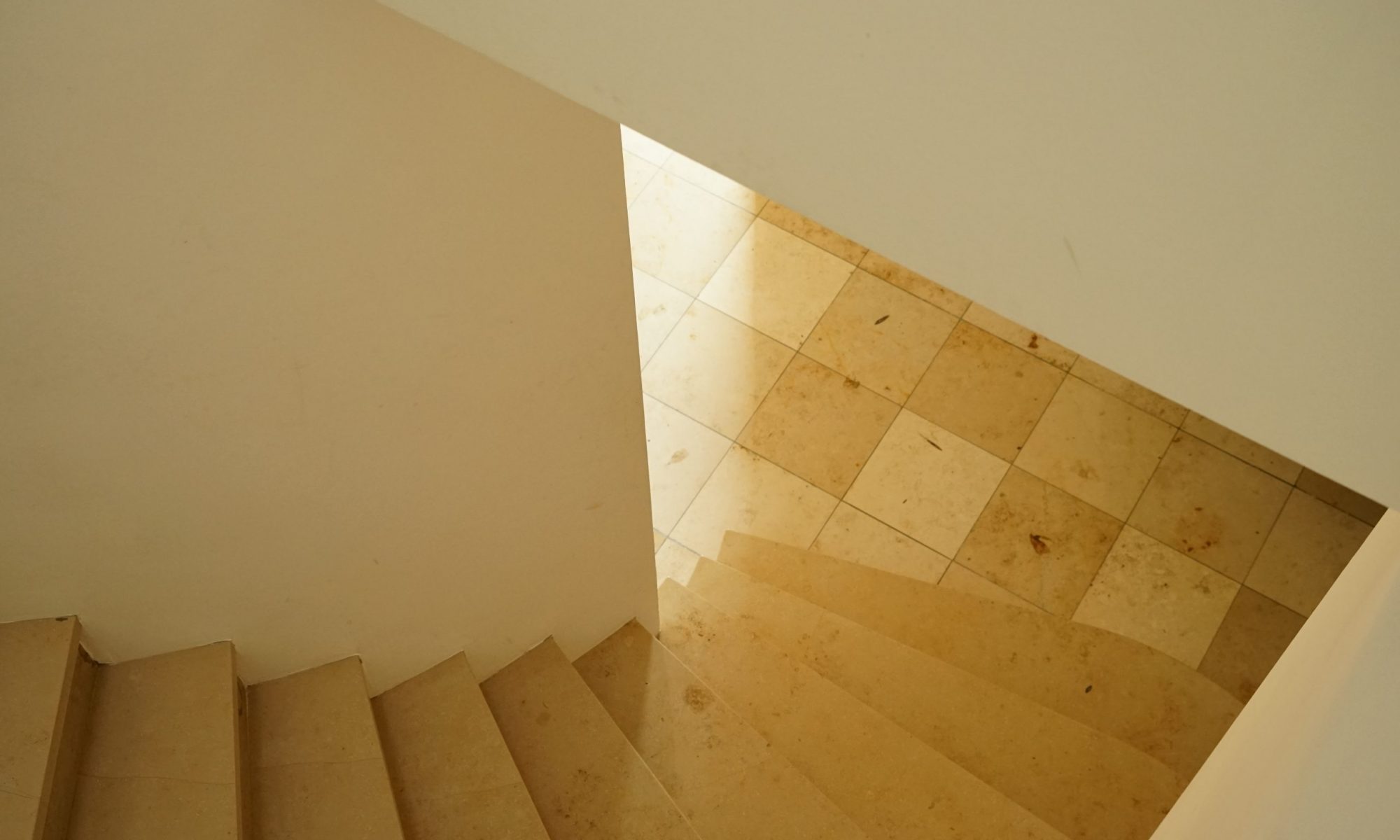Blick vom Obergeschoss hinunter auf die Antrittsstufe der Treppe